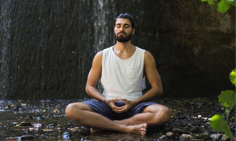 Egy nyugodt férfi meditál a természetben